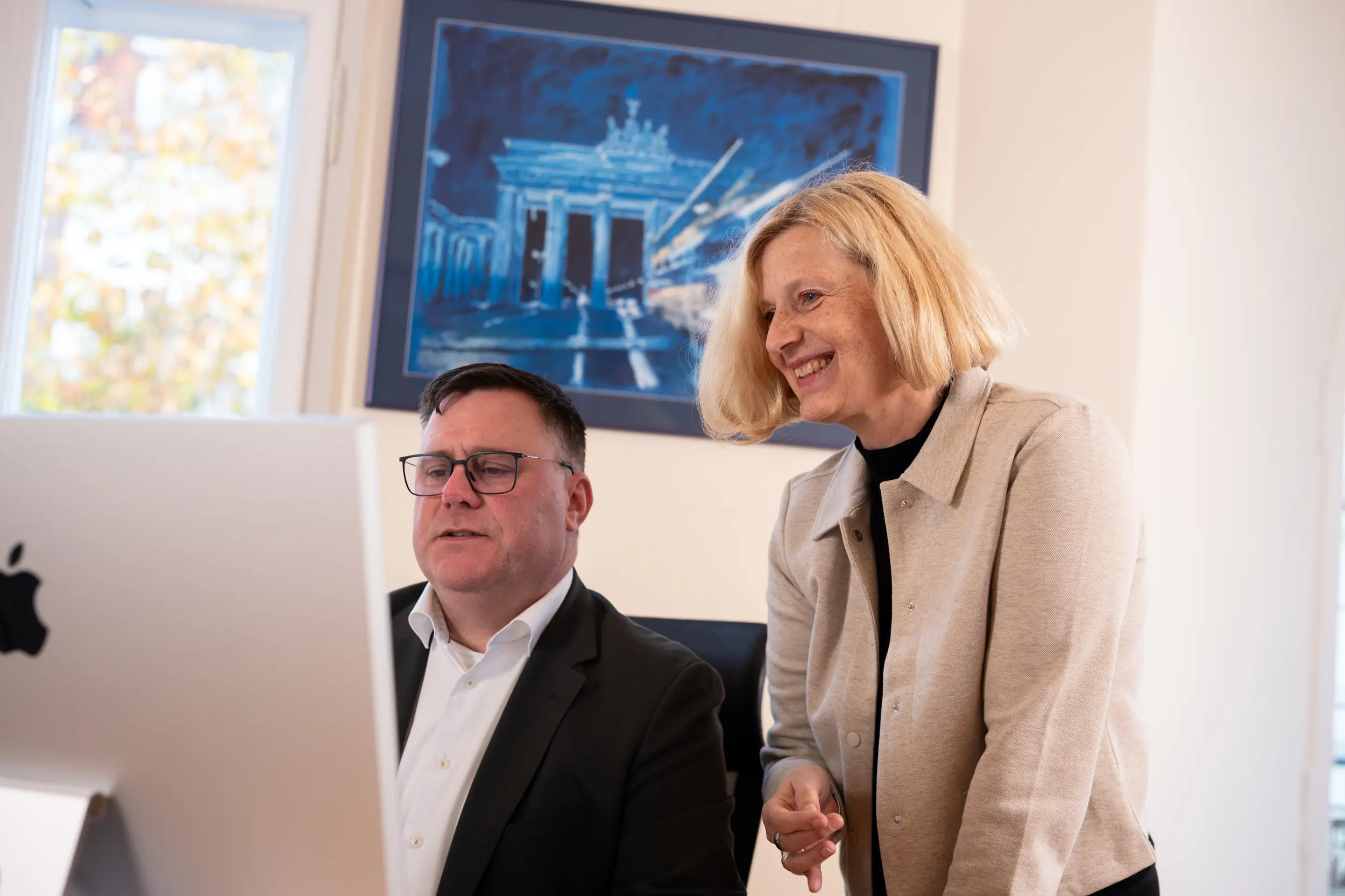 OMC Berater beim Executive Coaching im Berliner Büro mit Brandenburger Tor Kunstwerk